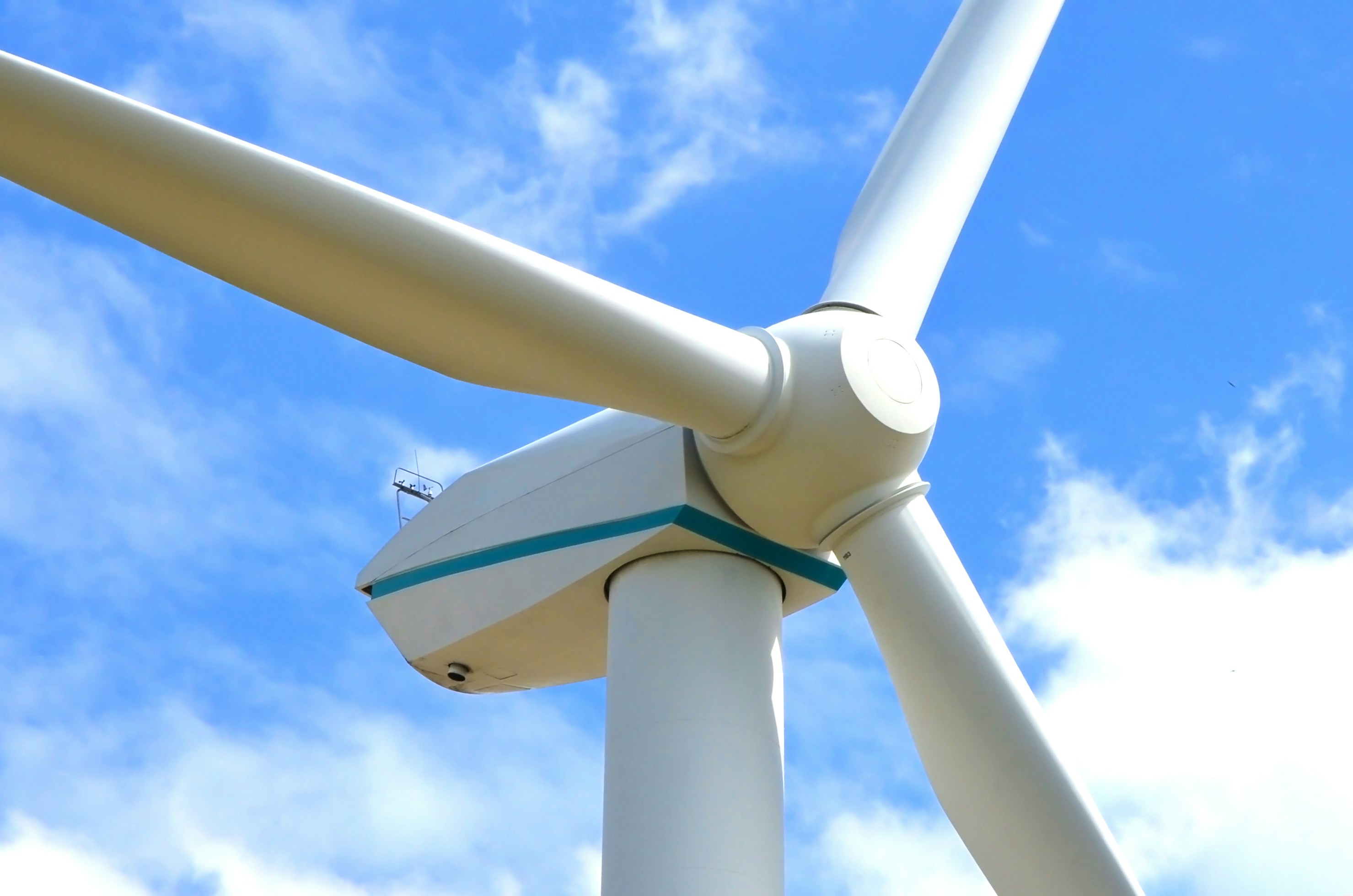 Close view of a wind turbine against a blue sky