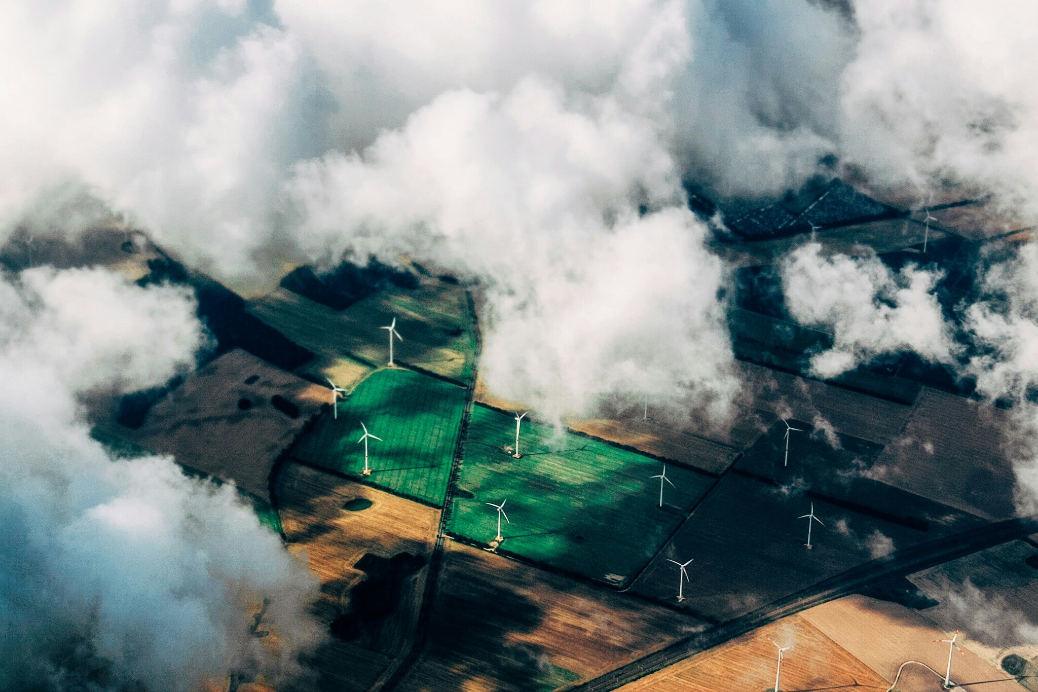 Aerial view of a solar plant with substation buildings among farmland