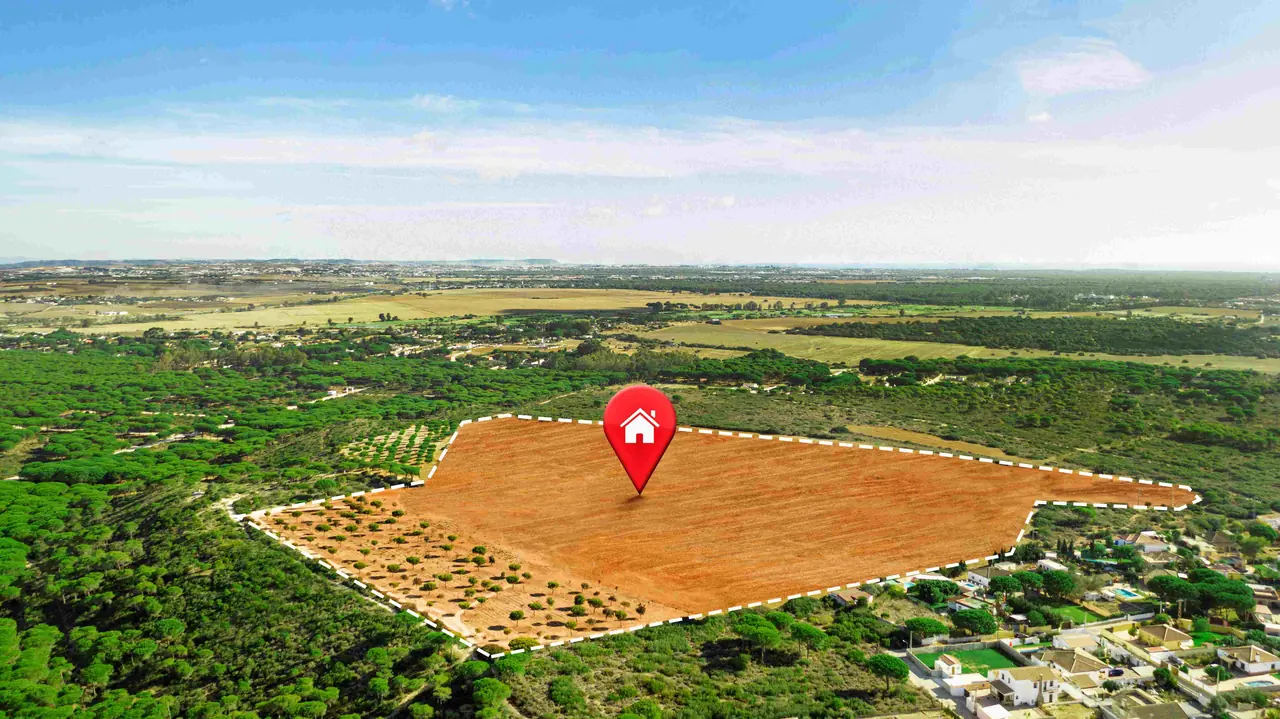 Aerial view of a marked parcel of land surrounded by green vegetation